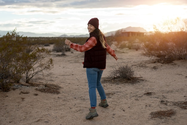 Mujer sonriente de tiro completo en el desierto americano