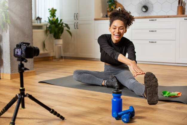 Mujer sonriente de tiro completo estirando la pierna