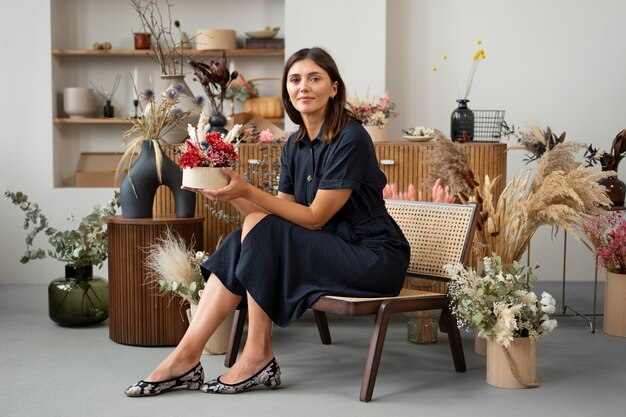 Mujer sonriente de tiro completo con flores