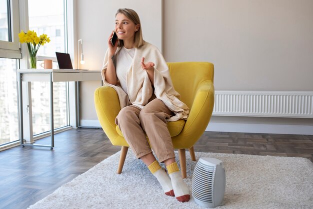 Mujer sonriente de tiro completo hablando por teléfono