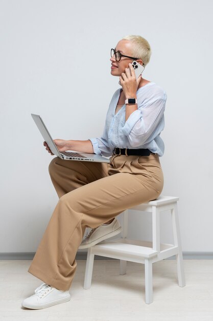 Mujer sonriente de tiro completo hablando por teléfono