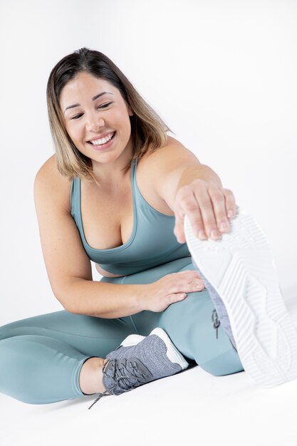 Mujer sonriente de tiro completo haciendo ejercicio