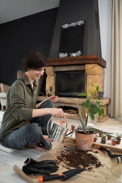 Mujer sonriente de tiro completo jardinería dentro