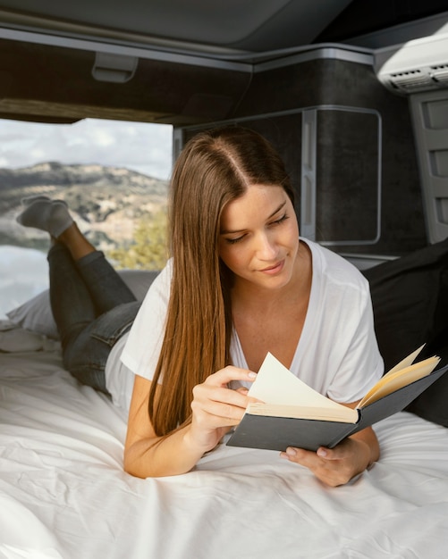 Mujer sonriente de tiro completo leyendo