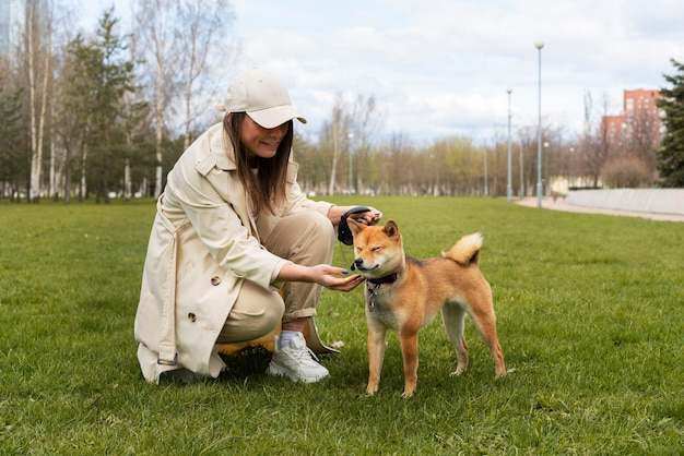 Foto gratuita mujer sonriente de tiro completo y lindo perro