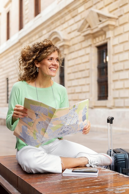 Mujer sonriente de tiro completo con mapa