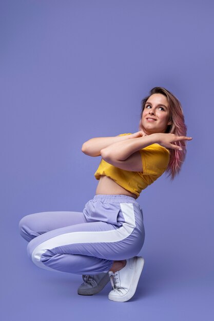 Mujer sonriente de tiro completo moviendo su cuerpo