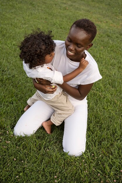 Mujer sonriente de tiro completo con niño