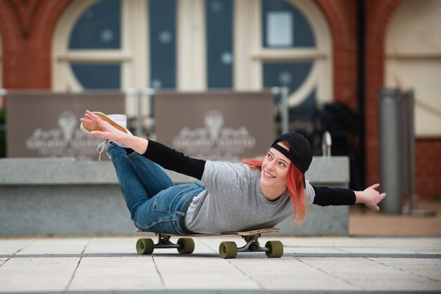 Mujer sonriente de tiro completo en patineta