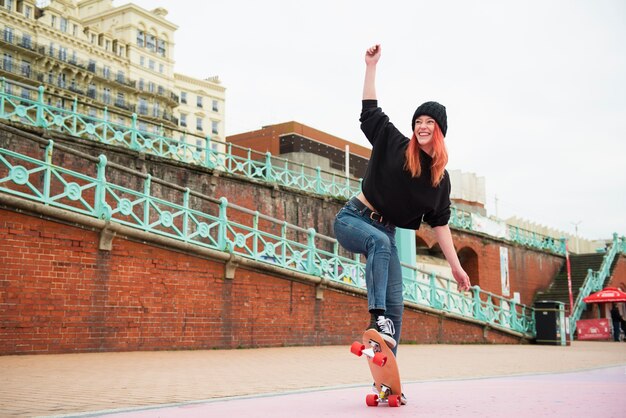 Foto gratuita mujer sonriente de tiro completo en patineta