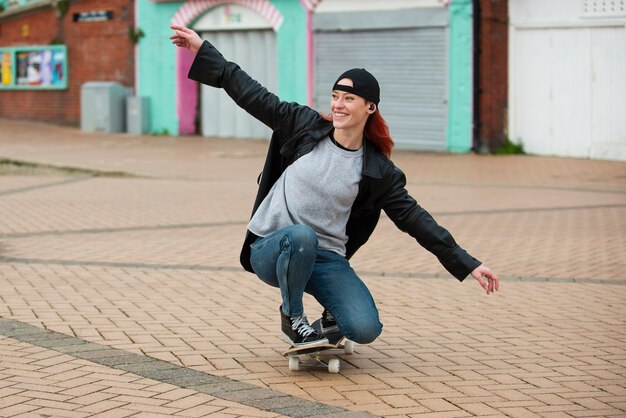 Mujer sonriente de tiro completo en patineta