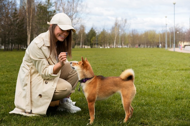 Mujer sonriente de tiro completo con perro shiba inu