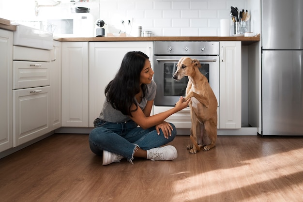 Mujer sonriente con tiro completo de perro