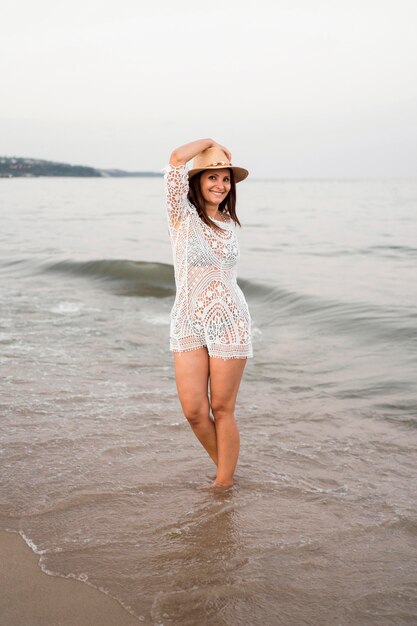 Mujer sonriente de tiro completo posando en el mar