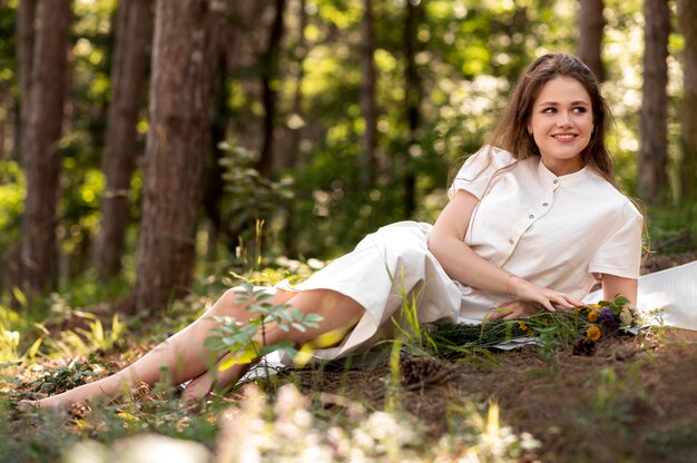 Mujer sonriente de tiro completo posando en la naturaleza