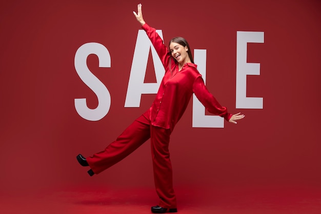 Mujer sonriente de tiro completo con ropa roja