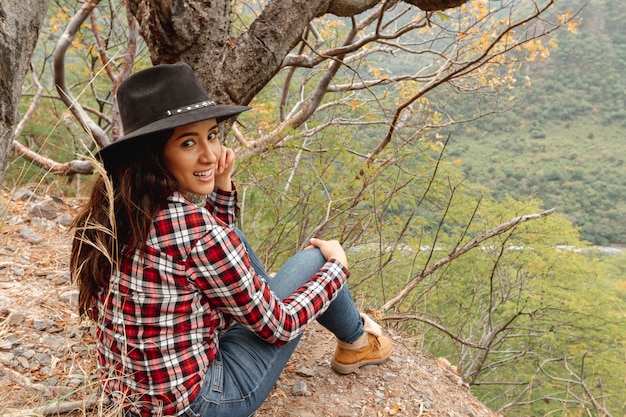 Foto gratuita mujer sonriente de tiro completo sentado al aire libre