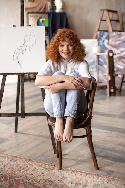 Mujer sonriente de tiro completo en silla