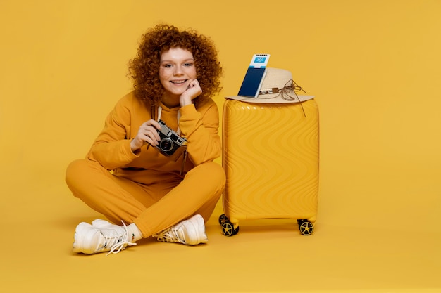 Mujer sonriente de tiro completo sosteniendo la cámara