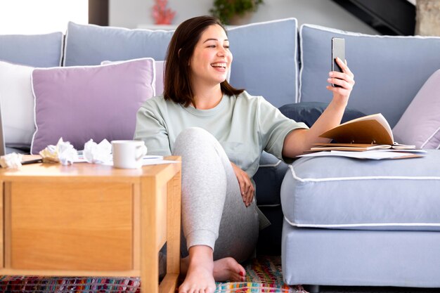 Mujer sonriente de tiro completo con teléfono