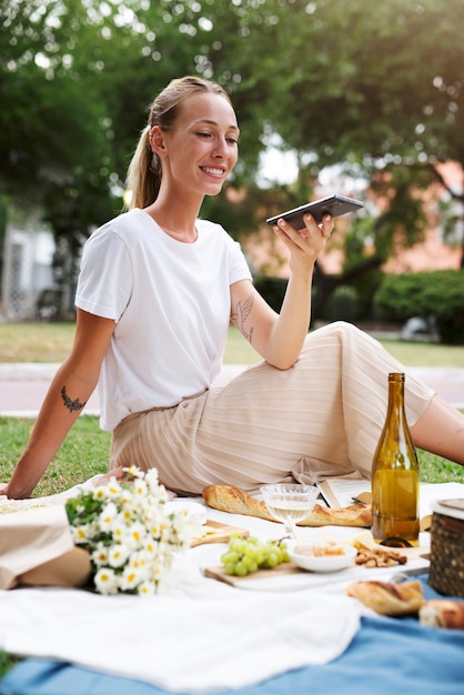 Mujer sonriente de tiro completo con teléfono