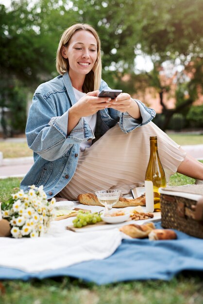 Mujer sonriente de tiro completo tomando fotos