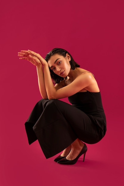 Mujer sonriente de tiro completo con vestido negro