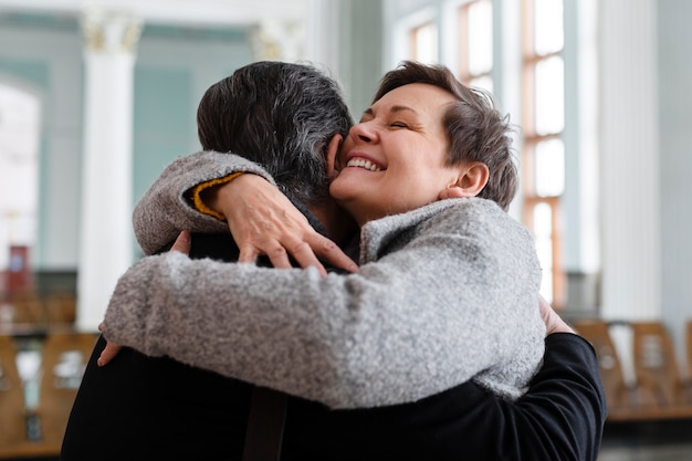 Mujer sonriente de tiro medio abrazando a hombre