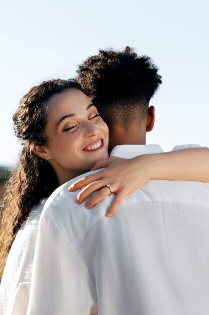 Mujer sonriente de tiro medio abrazando a hombre