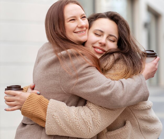 Mujer sonriente de tiro medio abrazándose