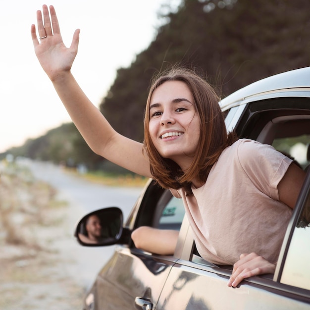 Mujer sonriente de tiro medio agitando