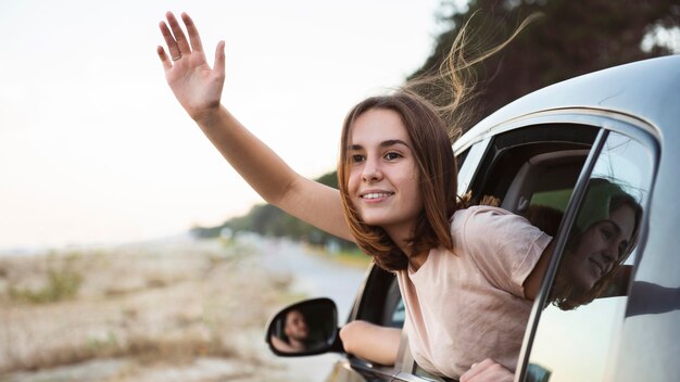 Mujer sonriente de tiro medio agitando