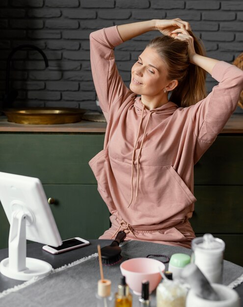 Mujer sonriente de tiro medio atando su cabello