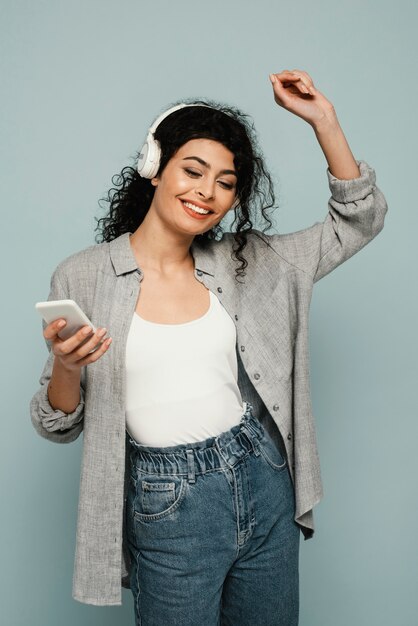 Mujer sonriente de tiro medio con auriculares