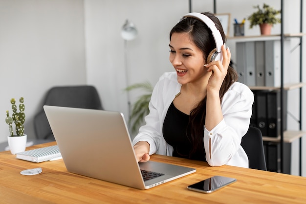 Mujer sonriente de tiro medio con auriculares