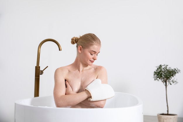 Mujer sonriente de tiro medio en la bañera