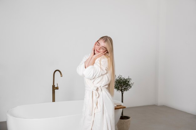 Mujer sonriente de tiro medio en el baño.