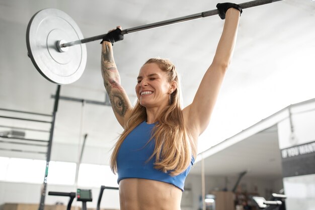 Mujer sonriente de tiro medio con barra