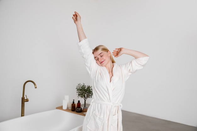 Mujer sonriente de tiro medio con bata de baño