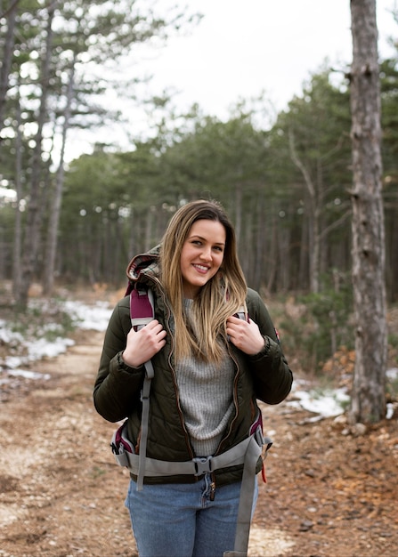 Mujer sonriente de tiro medio en el bosque