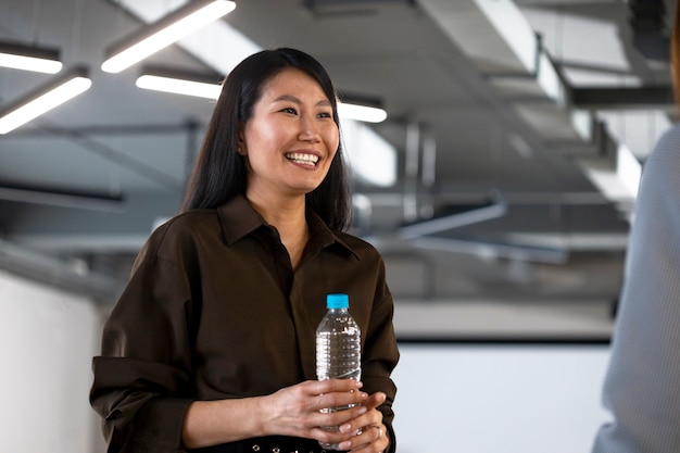 Foto gratuita mujer sonriente de tiro medio con botella de agua