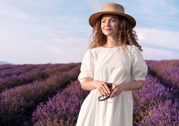 Mujer sonriente de tiro medio en campo de lavanda