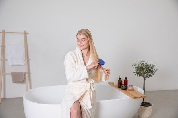 Mujer sonriente de tiro medio cepillarse el cabello