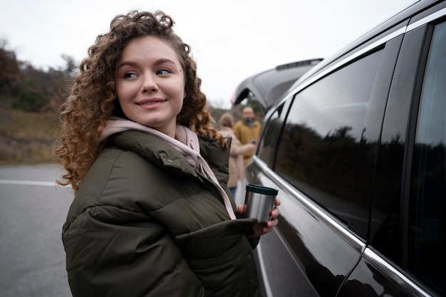 Mujer sonriente de tiro medio cerca del coche