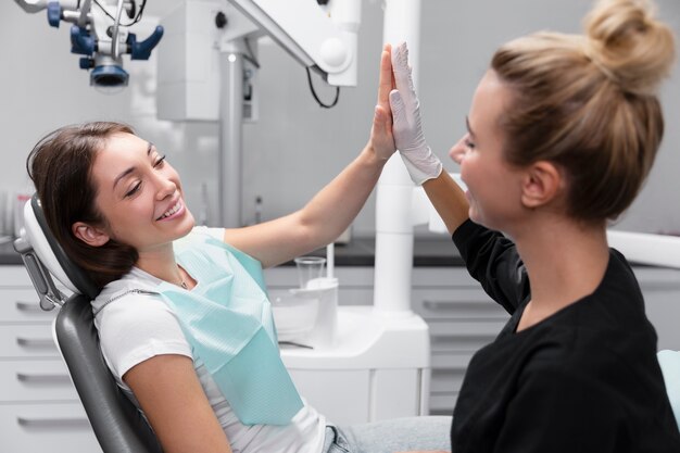 Mujer sonriente de tiro medio choca esos cinco