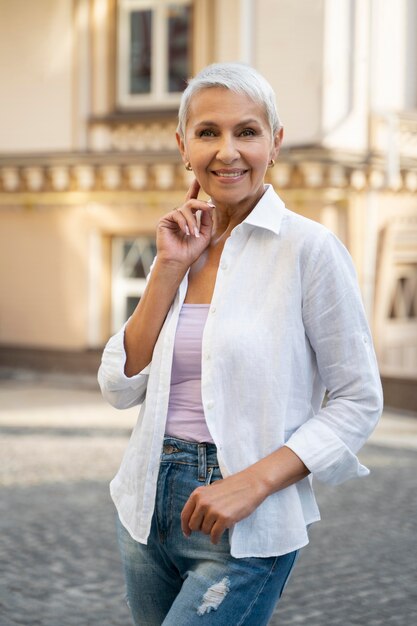 Mujer sonriente de tiro medio en la ciudad