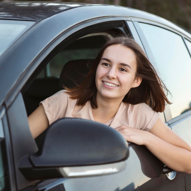Mujer sonriente de tiro medio en coche