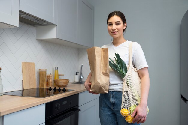 Mujer sonriente de tiro medio con comestibles