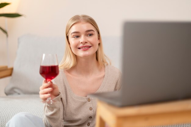 Mujer sonriente de tiro medio con copa de vino