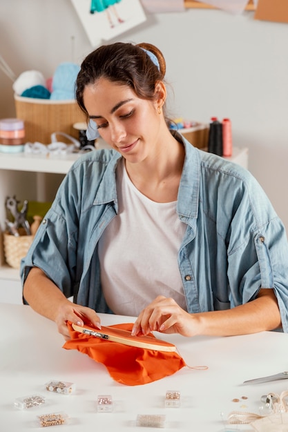 Mujer sonriente de tiro medio cosiendo